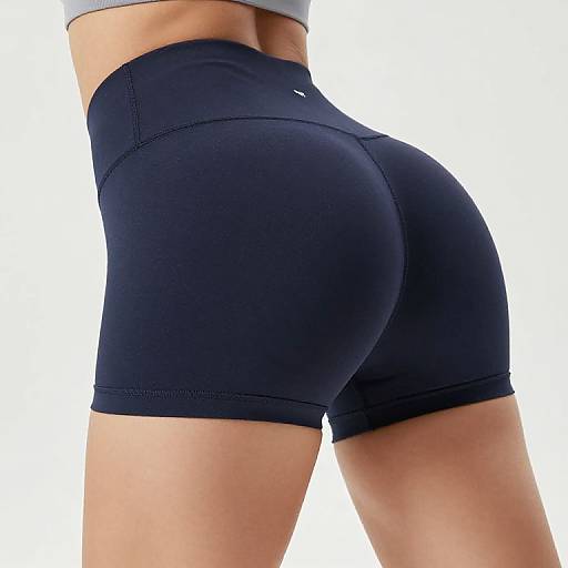 Photograph of a fit person's lower back and buttocks in tight, dark blue athletic shorts, showing a smooth, toned physique against a plain white