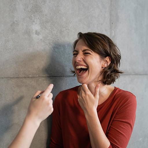 Joyful Woman Laughing Against Concrete Wall