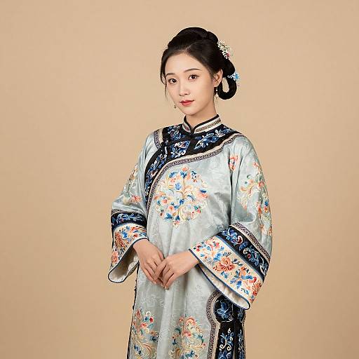 Photograph of an East Asian woman with fair skin, black hair in a bun, wearing a silver silk traditional Korean hanbok with blue and floral
