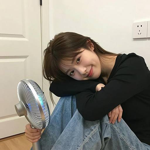 Young Woman Relaxing with Oscillating Fan