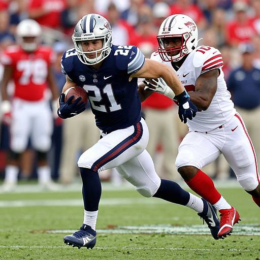 Photograph of an intense football game: A New England Patriots player in dark navy jersey, number 21, runs with the ball, being closely pursued