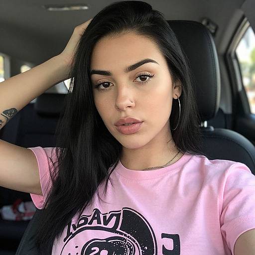 Photograph of a young Latina woman with long black hair, wearing a pink 