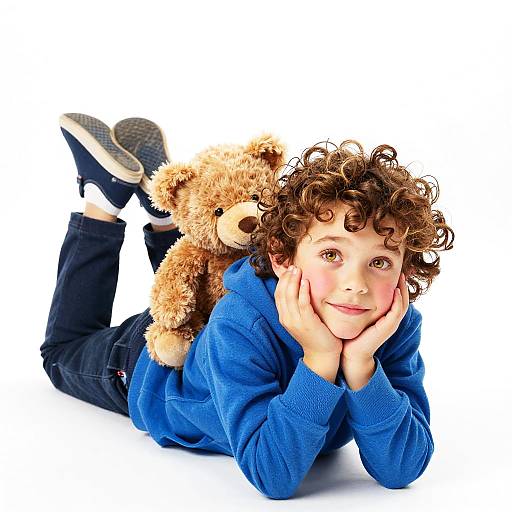 Curious Child with Teddy Bear Lying on Floor