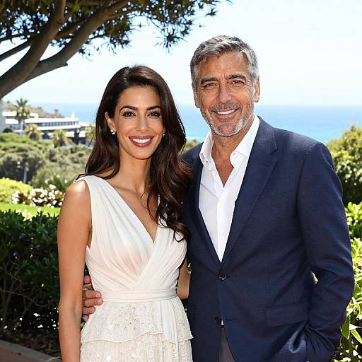 Photograph of a smiling middle-aged man with gray hair in a navy suit, white shirt, and a smiling woman with long black hair in a white