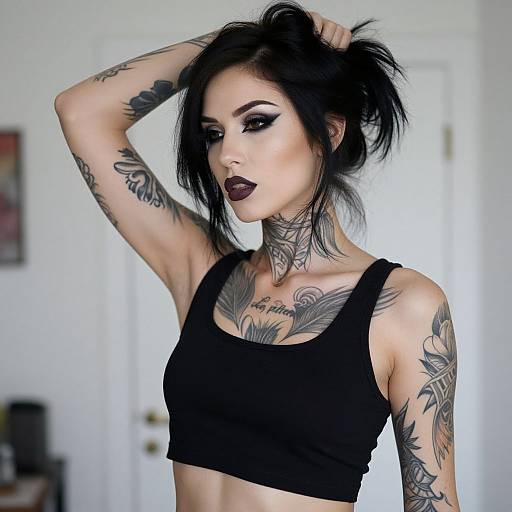 Photograph of a tattooed, pale-skinned woman with black hair, dark makeup, and black crop top, holding her hair up in a brightly