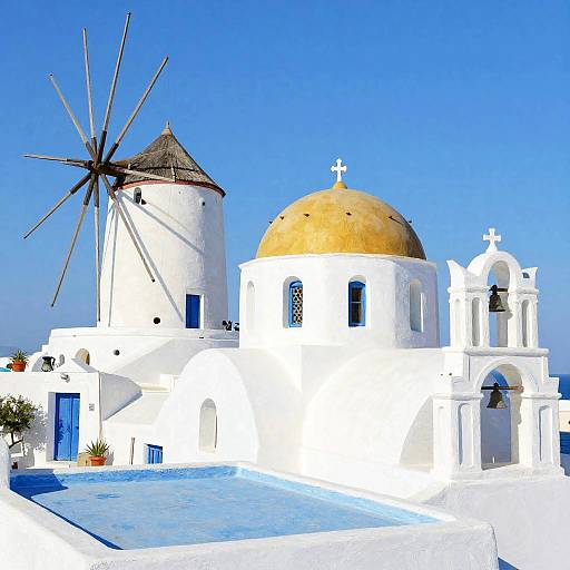 Photograph of a bright white Greek island church with a golden dome, windmill, blue doors, and clear blue sky.