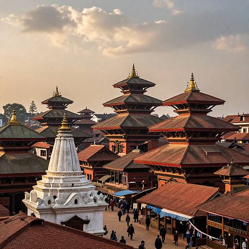 Photograph of Kathmandu's Boudhanath Stupa at sunset, showcasing tiered, dark-roofed pagodas, white st