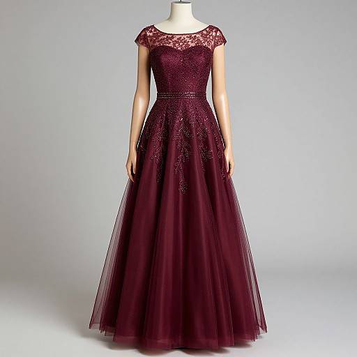 Photograph of a mannequin wearing an elegant, deep burgundy, lace-trimmed, floor-length gown with a fitted bodice and flowing
