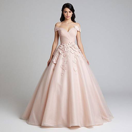 Photograph of a woman with dark hair in an off-shoulder, peach-colored, floral-embellished ball gown, standing against a plain