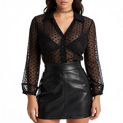 Photograph of a woman in a sheer black polka dot blouse, black leather skirt, choker necklace, white background, head partially cropped.