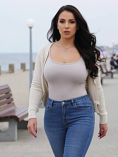 Photograph of a curvy woman with long black hair, wearing a white tank top, white cardigan, and blue jeans, walking confidently on a