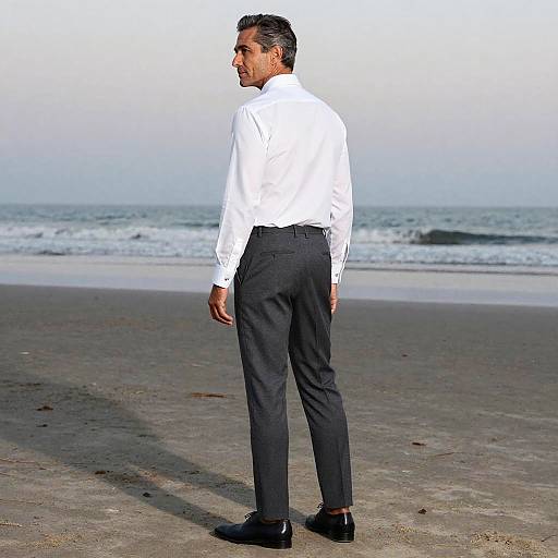 Middle-aged man in classic attire standing on beach