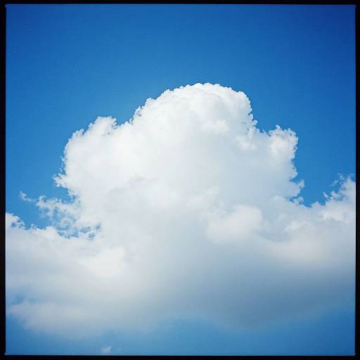 Photograph of a large, bright white cumulus cloud against a vivid blue sky, with sunlight illuminating the cloud's top.
