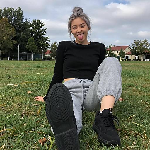 Young Woman Sitting on Grass with Extended Foot