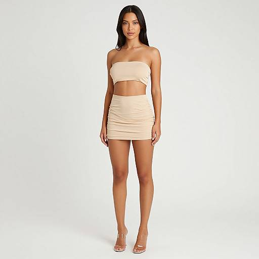 Photograph of a woman with long black hair, medium tan skin, and slim build, wearing a strapless beige bandeau top and matching ruch