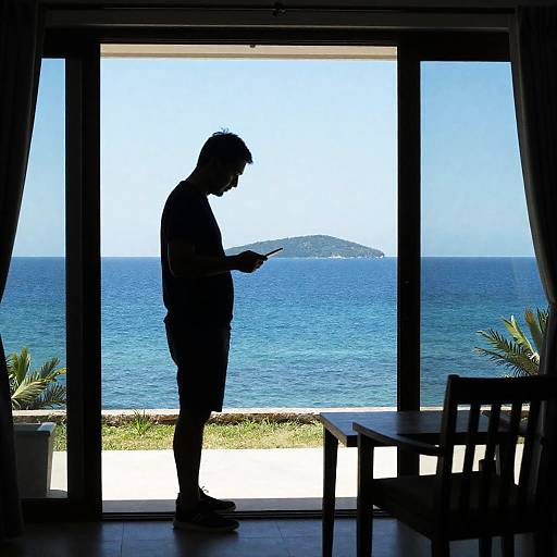 Silhouetted Man Using Phone by Ocean View