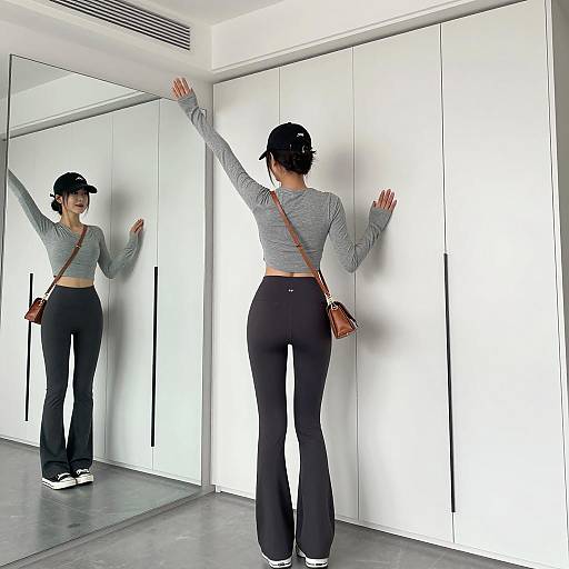 Woman in Crop Top and Flared Leggings by Closet