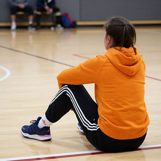 Woman Sitting on Basketball Court