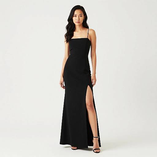 Photograph of an Asian woman with long black hair, wearing a sleek, black, floor-length dress with a high slit, standing against a plain white