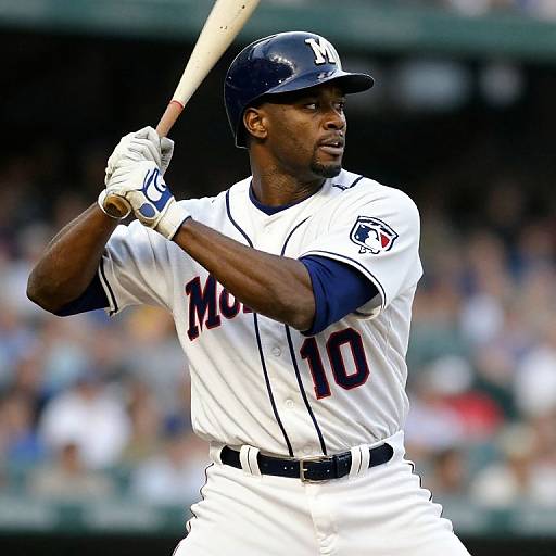 Photograph of a muscular black male baseball player in a white and navy uniform, number 10, mid-swing, focused expression, stadium background.