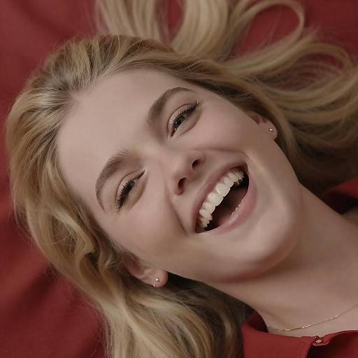 Smiling Blonde Woman Lying on Red Fabric