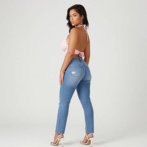 Photograph of a curvy woman with long black hair, wearing a pink halter top, blue high-waisted jeans, and white heels,