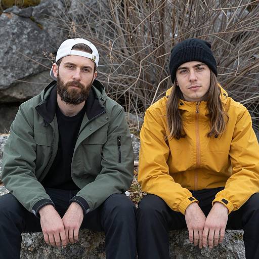 Two men sitting outdoors on rocks
