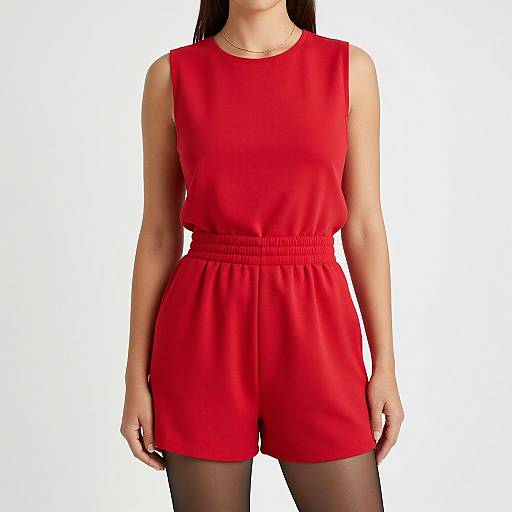 Photograph of a woman in a sleeveless, red, high-waisted romper with a gathered waist, black tights, and a thin