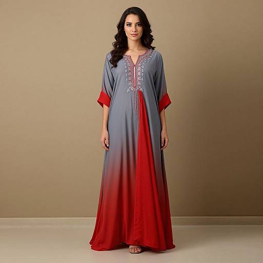 Photograph of a dark-haired woman in a long, gradient grey-to-red traditional dress with red cuffs and intricate silver embroidery, standing against a beige background