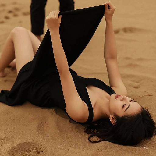Woman in Black Dress Lying on Sand