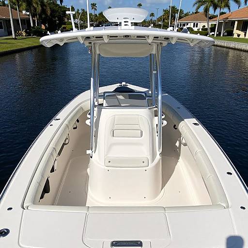 Photograph of a white boat viewed from the rear, docked in a calm, blue-water marina with palm trees and houses in the background.