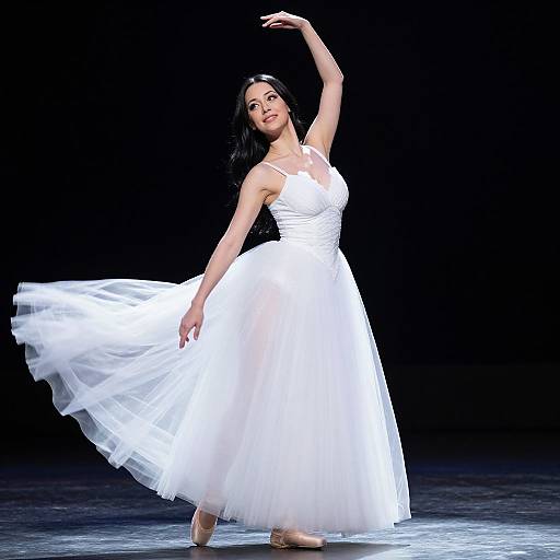 Photograph of a dark-haired woman in a flowing white dress, elegantly dancing with one arm raised, against a black background.