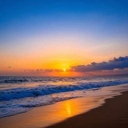 Photograph of a vibrant sunset over a beach, with golden sun reflecting on wet sand, waves crashing, and a gradient sky from blue to orange.