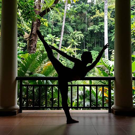 Silhouetted dancer with arms raised stands on tiled balcony, framed by lush tropical forest and columns, in vibrant photograph.