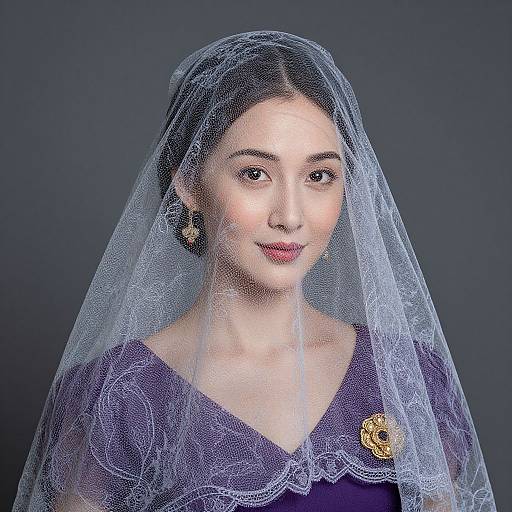 Photograph of a young Asian woman with fair skin, wearing a translucent blue lace veil, purple dress, and gold flower brooch, against a dark