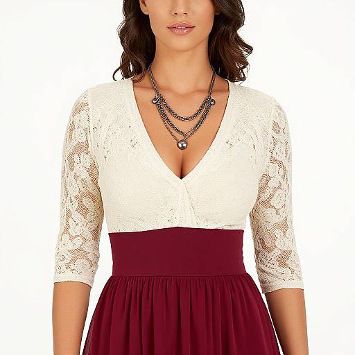 Photograph of a woman with medium skin tone, dark wavy hair, wearing a white lace V-neck top, maroon skirt, and layered black