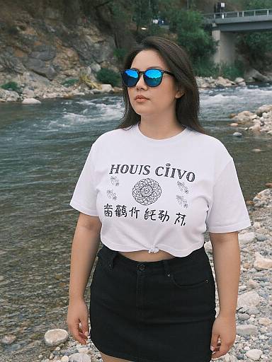 Photograph of an Asian woman with long dark hair, blue mirrored sunglasses, white 