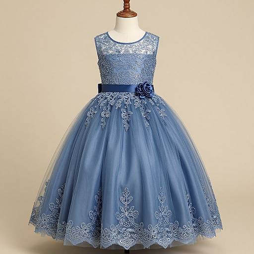 Photograph of a blue lace and tulle sleeveless dress with a wide skirt, blue belt, and flower detail, displayed on a white dress form