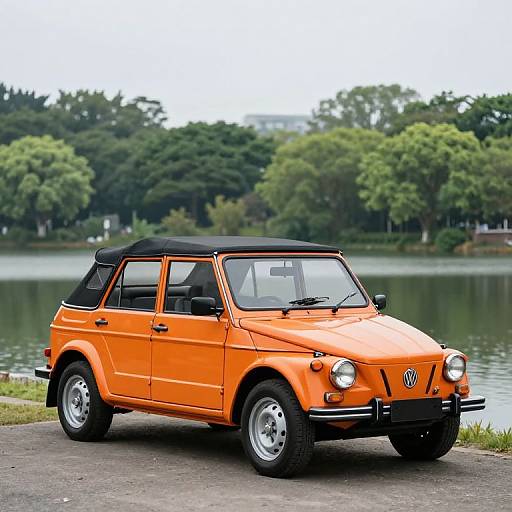 Photograph of a vibrant orange vintage Volkswagen Beetle convertible with black soft top, parked by a serene lakeside with lush green trees in the background.