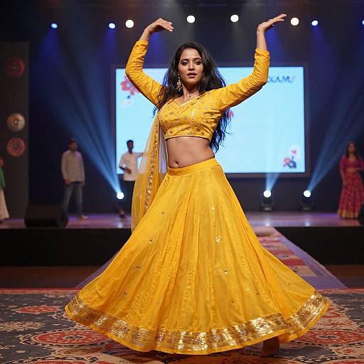 Photograph of a confident Indian woman in a bright yellow traditional outfit, dancing on a stage with dramatic lighting and a colorful rug.