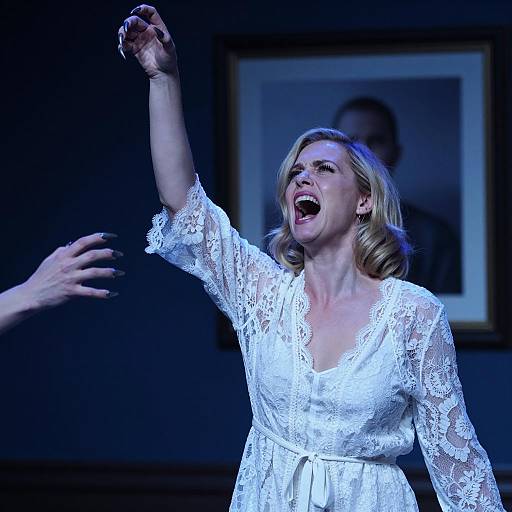 Intense woman screaming with claw-like fingers in white lace robe