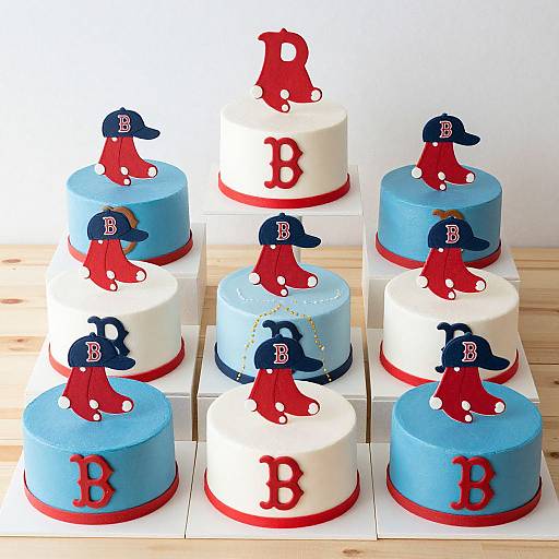 Photograph of six colorful baseball-themed cakes, alternating blue and white tiers, adorned with red baseball caps and letters (A, B, D).