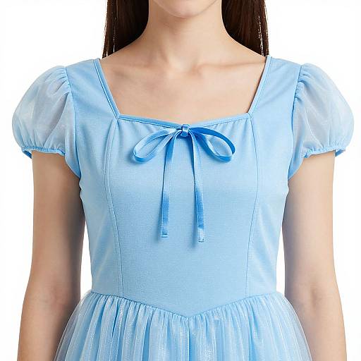 Photograph of a young woman in a light blue, short-sleeved, square-neck dress with puffed sleeves and a ribbon bow at the chest