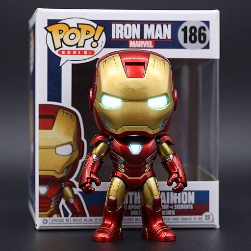 Photograph of a chibi-style Iron Man figure in red and gold, with glowing eyes, in front of its box. Box reads 