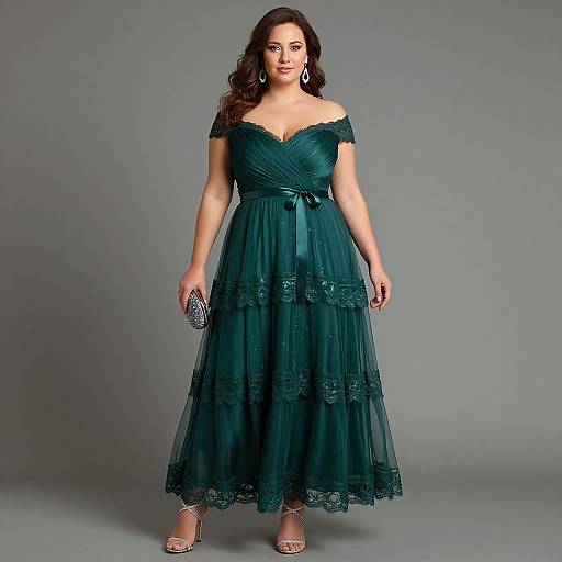 Photograph of a curvy woman with long brown hair in an off-shoulder, teal lace dress, holding a silver clutch, standing against a