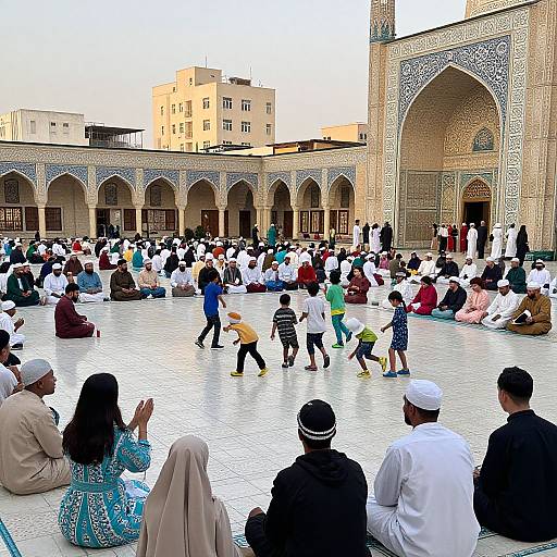 Photograph of diverse people, including children, sitting and playing in a sunlit, intricately patterned mosque courtyard with arches and minaret.