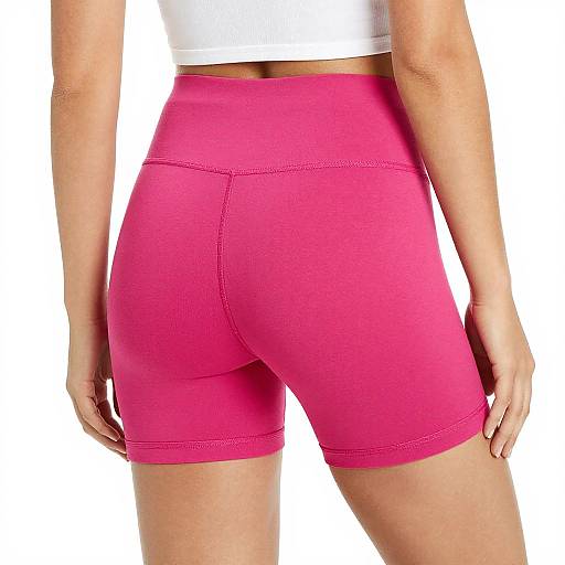 Photograph of a woman's lower back and buttocks in bright pink, high-waisted, form-fitting shorts, wearing a white cropped top