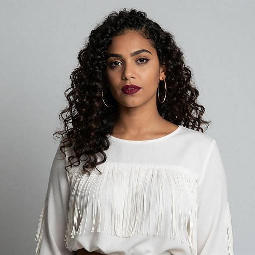 Confident Woman with Curly Hair and White Fringed Blouse