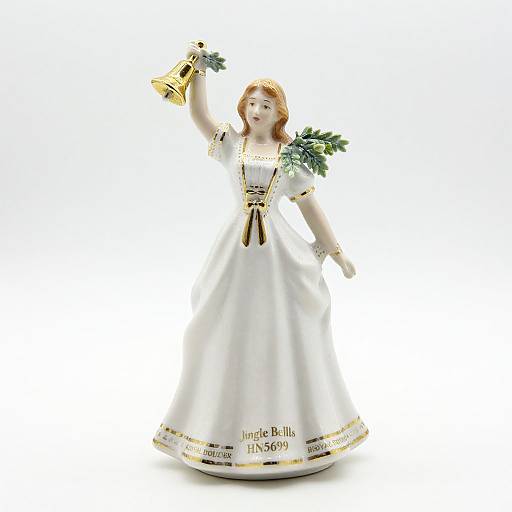 Photograph of a white porcelain angel figurine with gold accents, holding a golden bell, wearing a white dress with gold trim, standing against a white