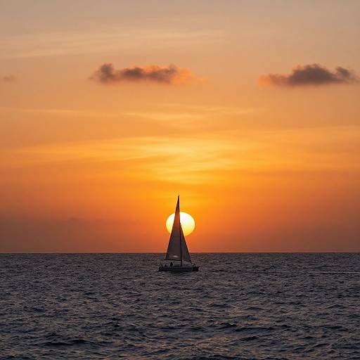 Photograph of a small sailboat with a raised sail, centered against a vibrant orange and yellow sunset over a calm ocean.